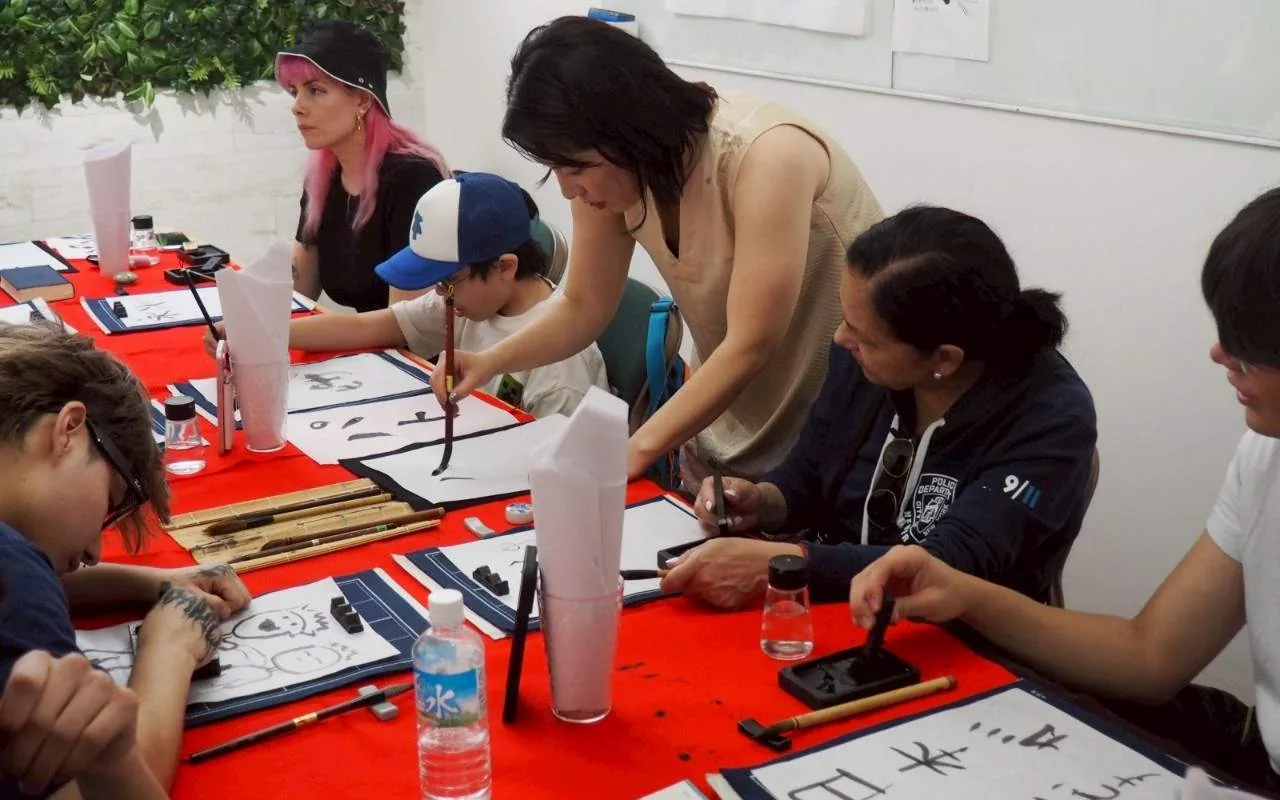 Guests concentrating on their brush strokes at the writing tables